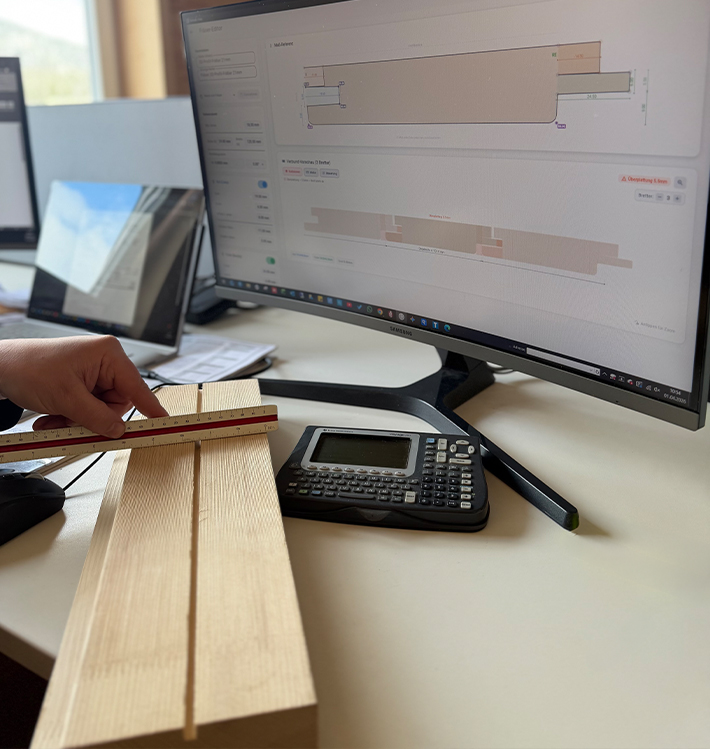 Qualitätskontrolle von Hobelware mit Lineal am Schreibtisch