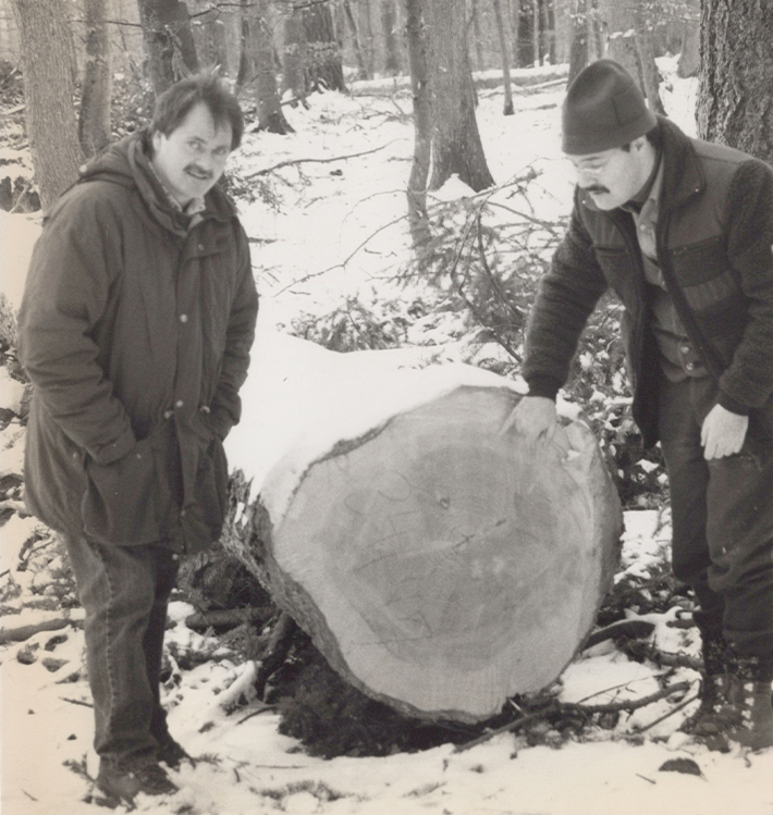 Junger Eckhard Wolf mit Partner bei Baumstamm.